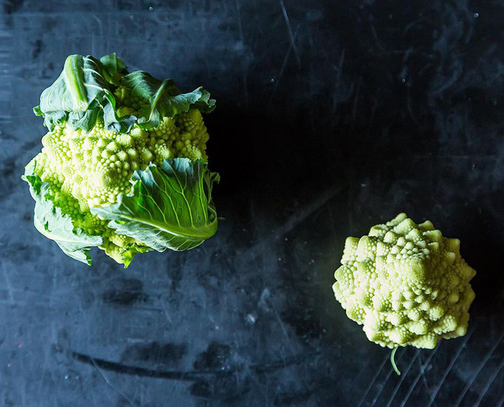 One regular size Romanesco salad next to a mini size salad on a dark blue background