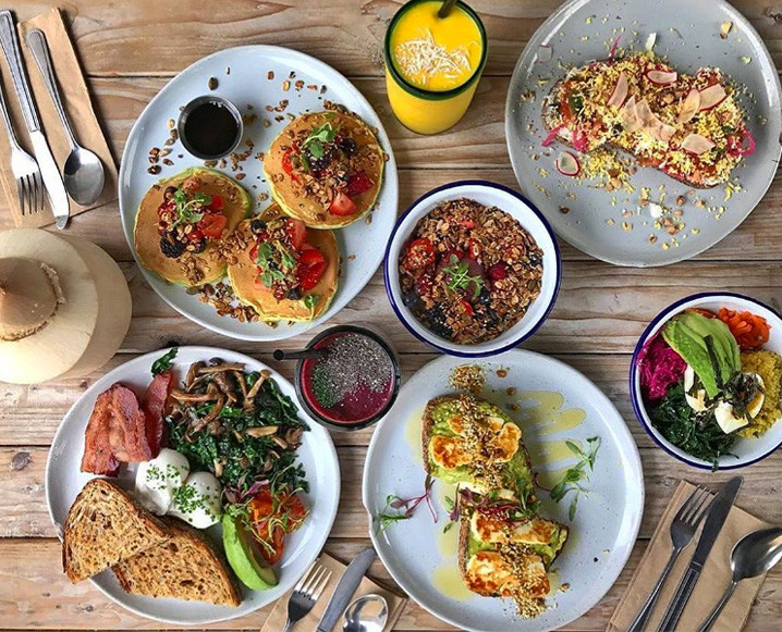 Aerial view of a table with brunch dishes, including pancakes, toast, poached eggs and more